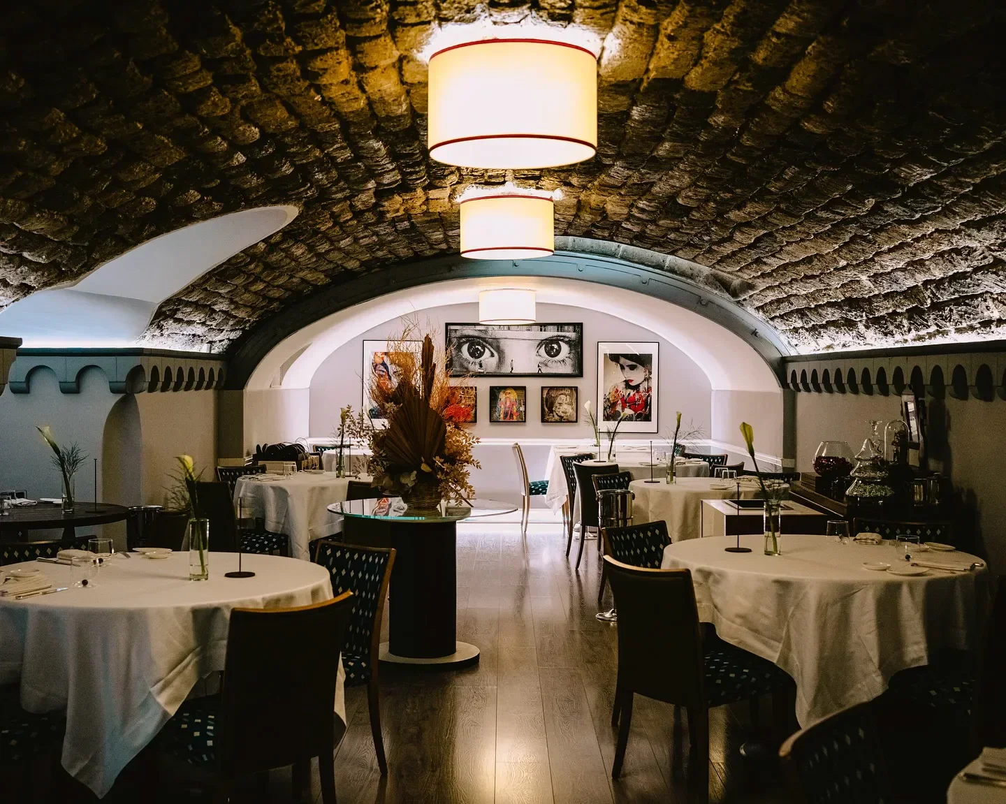 Elegant interior of Il Buco restaurant, Amalfi Coast, with art and arched ceilings.