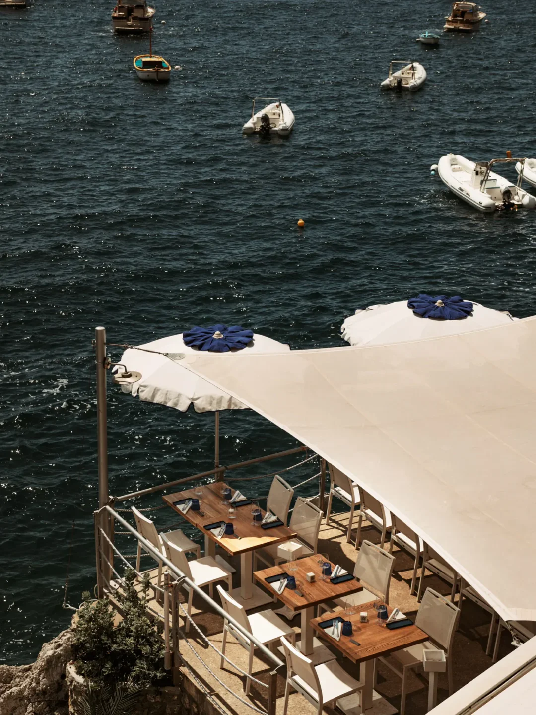 Il Pirata Praiano beach club dining area with tables set overlooking the boats on the Amalfi Coast.