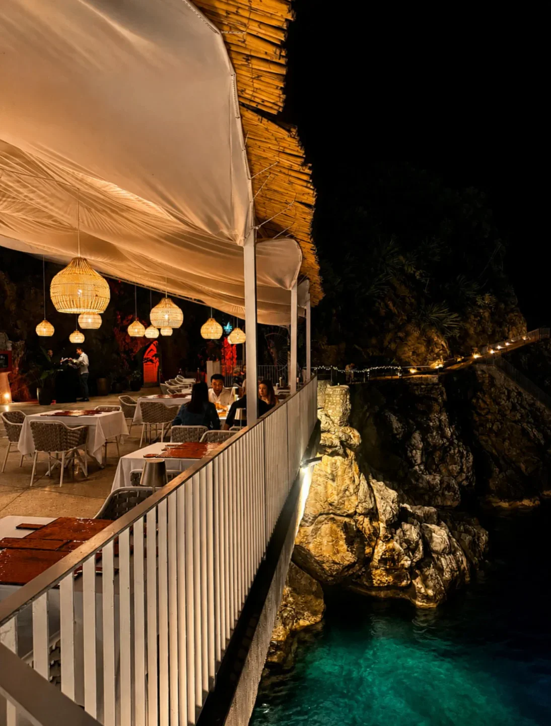 Le Grotte dell'Africana nightclub on the Amalfi Coast with illuminated rocky cove and ocean.